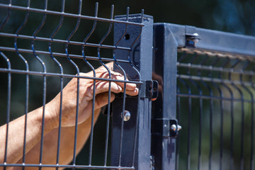 hands fastening clips on mesh fencing