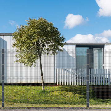 White building with fence and tree